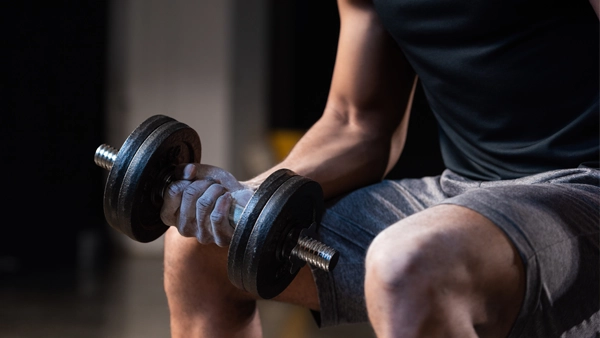A man using a hand weight at the gym